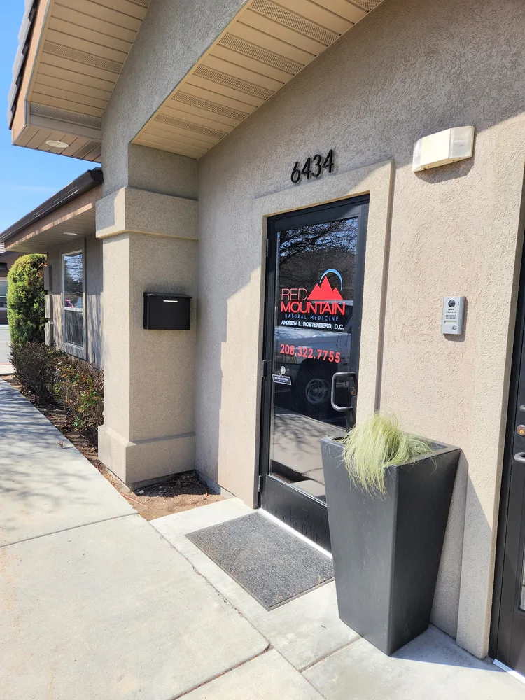 Storefront entrance to Red Mountain Natural Medicine at 6434 W Interchange Lane, Boise — glass door with Red Mountain logo and Dr. Andrew L. Rostenberg, DC name