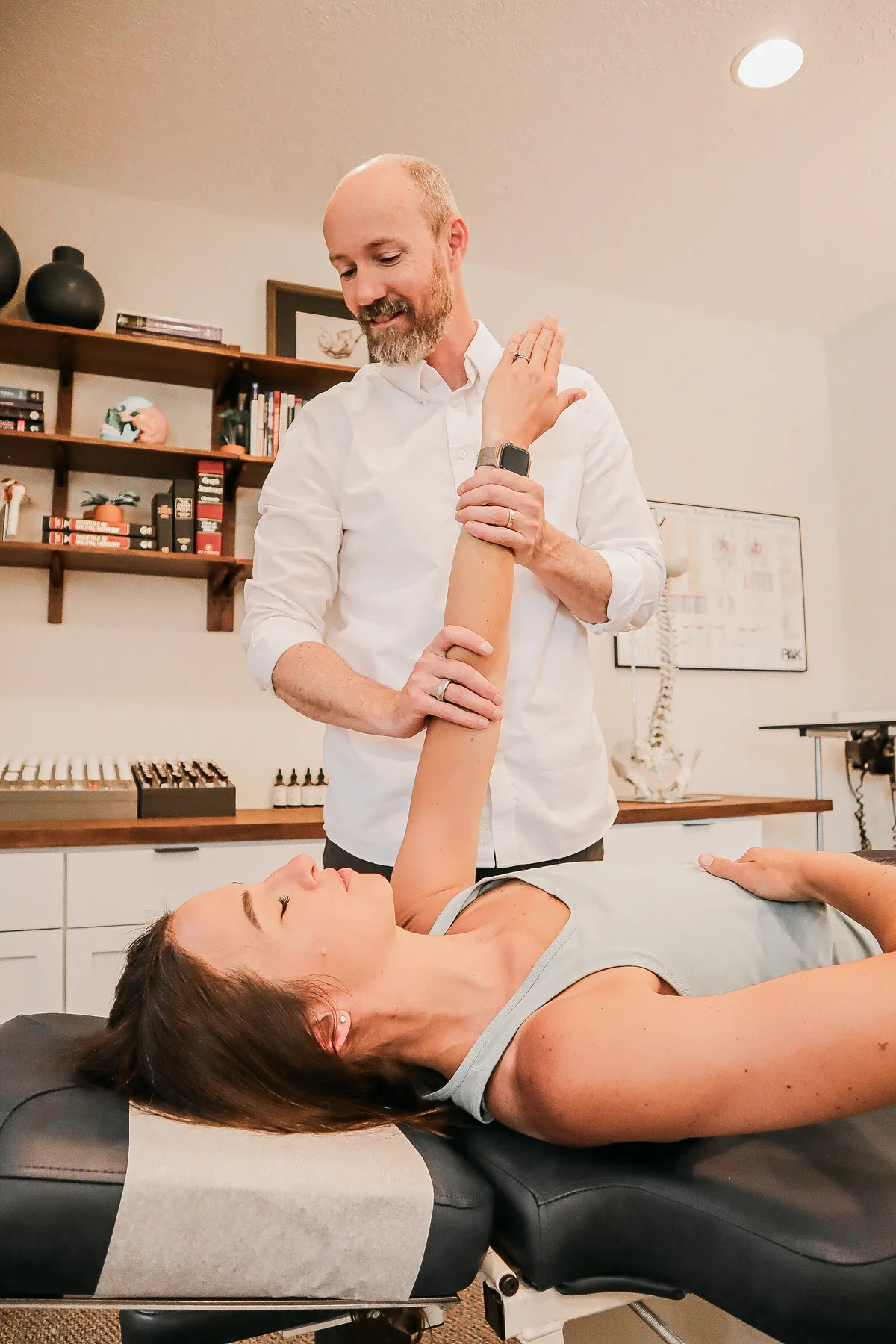 Dr. Andrew Rostenberg evaluating shoulder mobility with a patient at Red Mountain Natural Medicine in Boise, Idaho — a hands-on functional exam, not a rushed checklist
